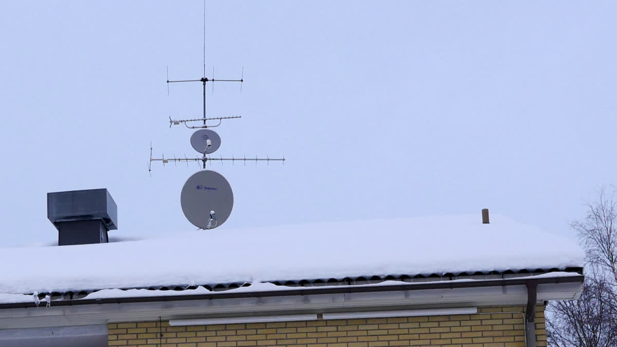 Ett antal antenner och paraboler på ett tak.